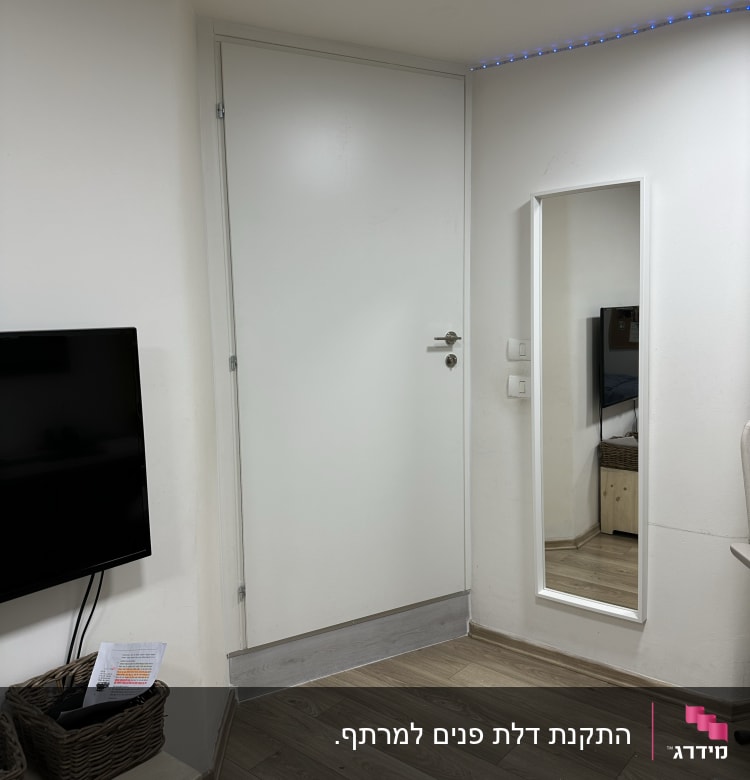 דלת לבנה עם ידית כסופה ומראה בצד